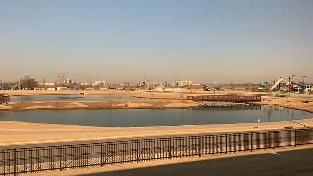 Wide view of a pond, footbridge and recreation grounds in Moore, Oklahoma