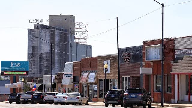 Downtown Yukon storefronts along Route 66 with the flour mill rising above the rooftops