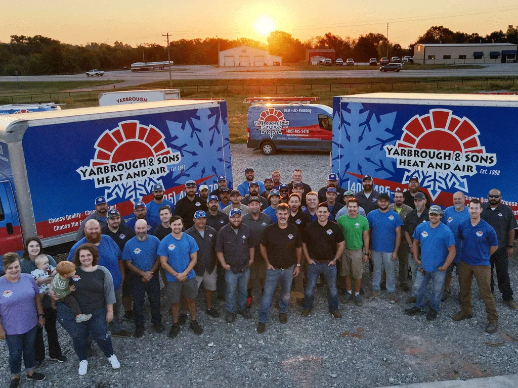 A group of people standing in front of two large trucks.
