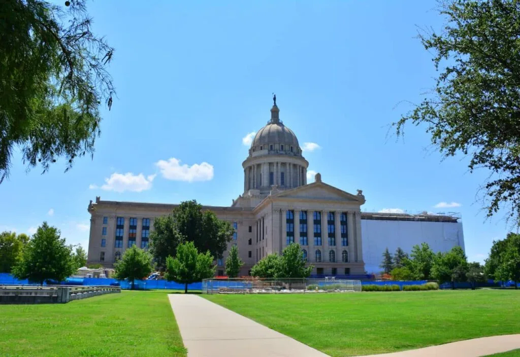 State capitol building under a clear blue sky with green lawns.