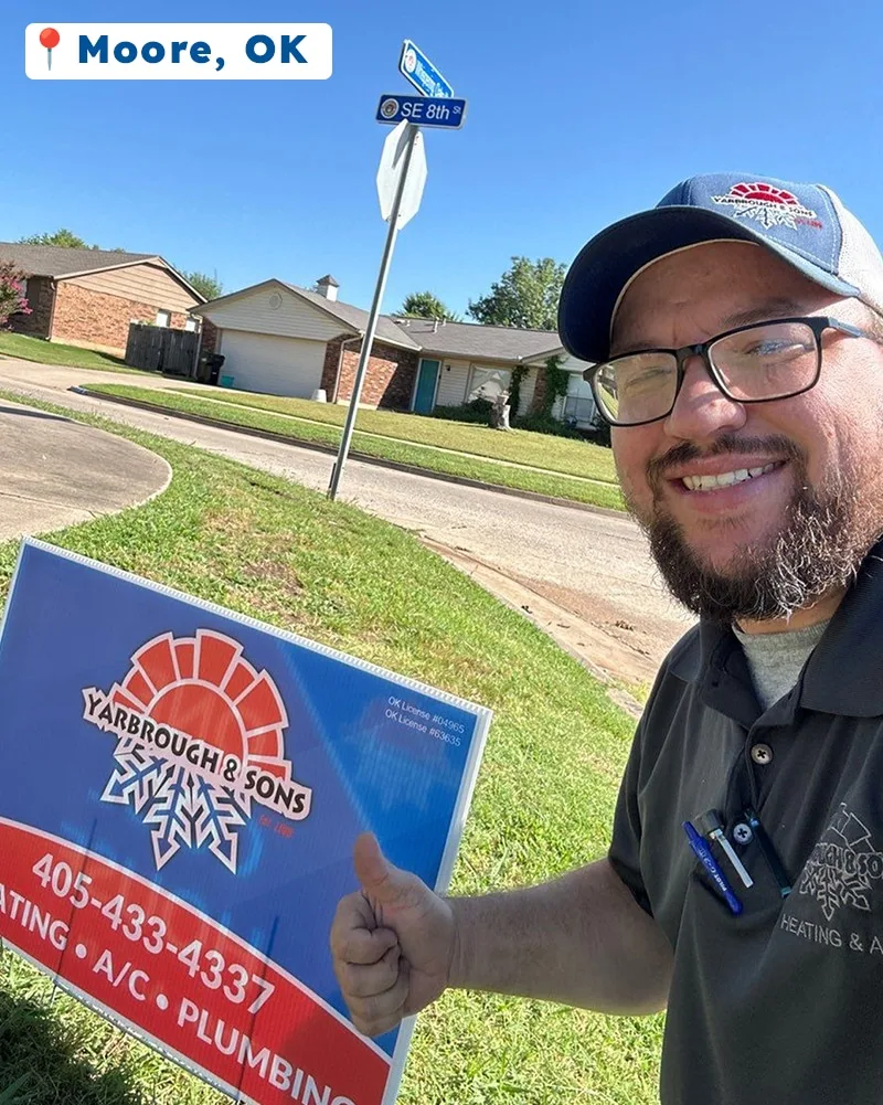 Yarbrough & Sons technician giving a thumbs up next to a branded “One Cool House” yard sign in Moore, OK, with a clear blue sky and residential neighborhood in the background.