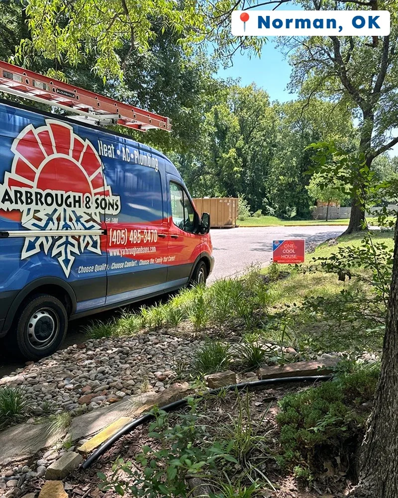 Yarbrough & Sons service van parked on a driveway in Norman, OK, with a “One Cool House” yard sign placed near the street.