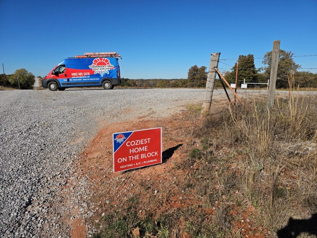 A Yarbrough & Sons service van parked beside a gravel road with a yard sign reading 'Coziest Home on the Block,' set against a rural backdrop in Blanchard, OK.