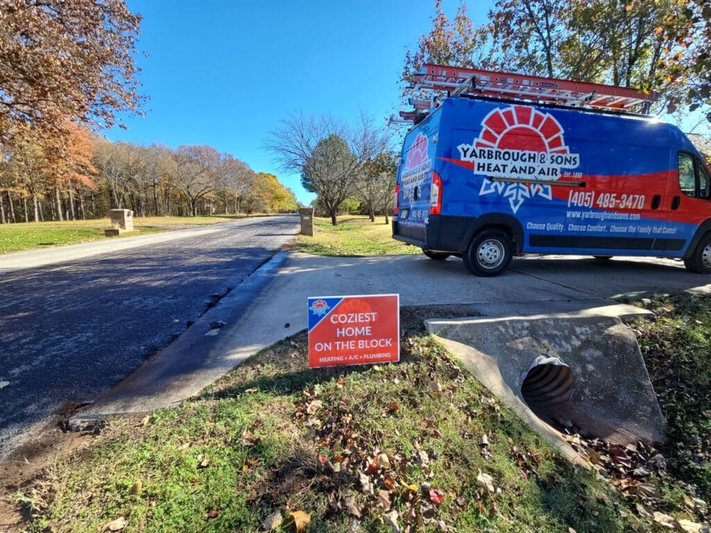 Yarbrough & Sons service van parked near a home in Norman, OK, with a "Coziest Home on the Block" yard sign after a heat pump tune-up.