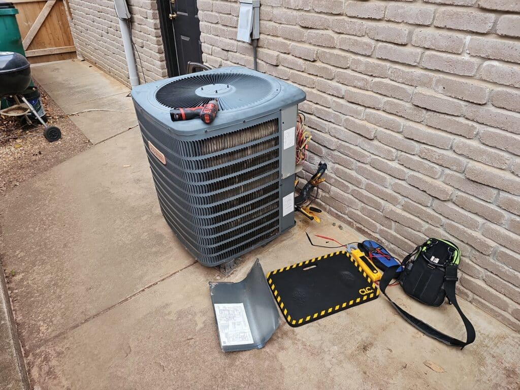 Outdoor condenser unit near a brick house inspected by Yarbrough & Sons during a maintenance visit in SW OKC.