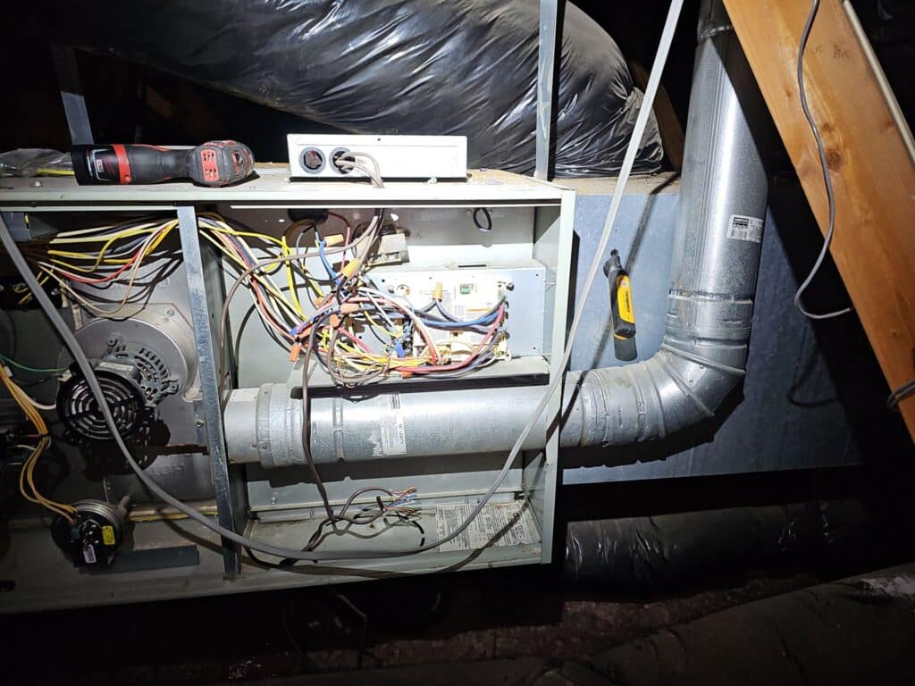 Interior view of a dual-fuel furnace showing wiring and components during a maintenance inspection in SW OKC