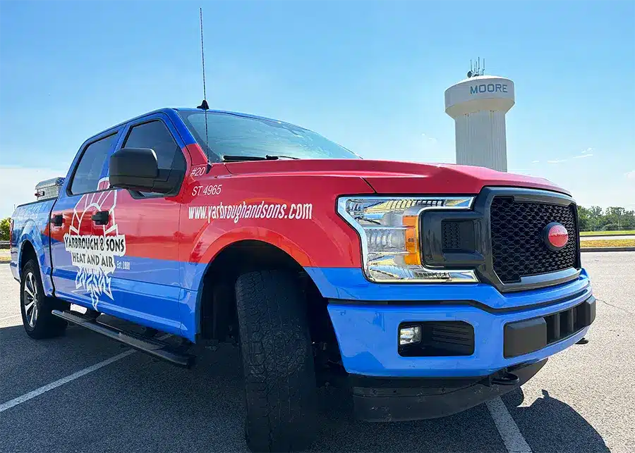 Yarbrough & Sons Heating, Cooling & Plumbing truck sits in front of a Moore water tower in Moore, OK.