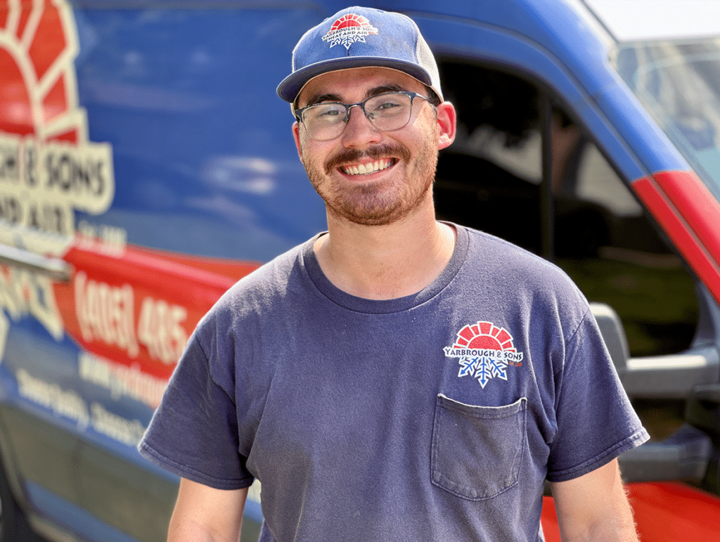 Yarbrough & Sons AC maintenance technician stands next to his service vehicle.