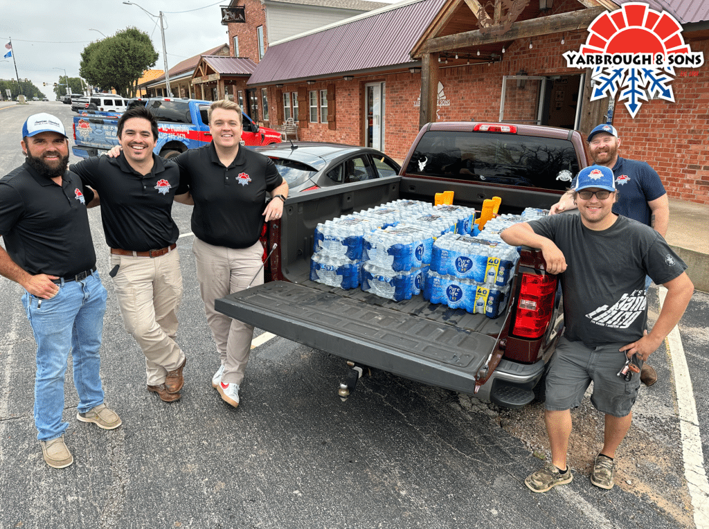 Yarbrough & Sons poses next to a truck load of 1,200 water bottles donated to Bridge Creek High School band in 2024.